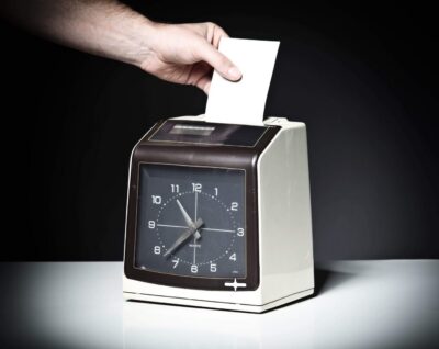 Hand inserting card into time clock.