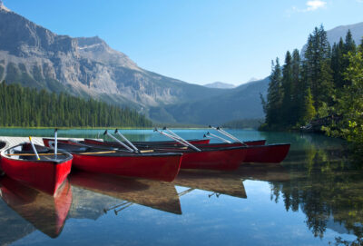Docked red canoes reflecting on turquoise water