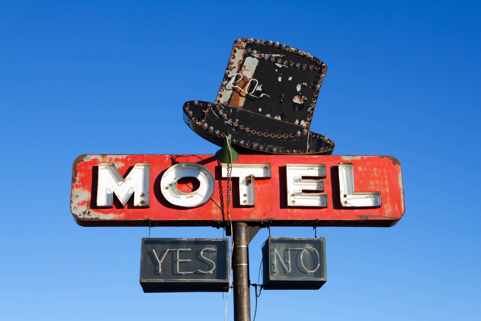 Vintage motel sign with top hat decoration.