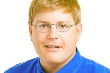 Man with glasses in blue shirt